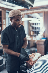 Canvas Print - Concentrated man shaving face on his client