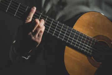 Wall Mural - Close up on midsection of man Playing a guitar 