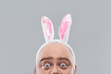 Close up of bold head of surprised man with bunny ears