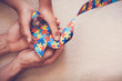Hands holding puzzle ribbon for autism awareness