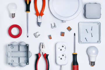 Different electrical tools on light grey background, top view. Electricity concept.