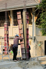 The construction technician is working on the casting of concrete pillars.