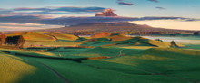 Mount Taranaki Under The Blue Sky With Grass Field And Cows As A Foreground In The Egmont National Park, The Most Symmetrical Volcanic Cones, Taranaki, New Zealand Green Farmland In The Foreground