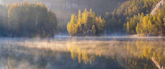 Wall Mural - autumn forest reflected in water. colorful autumn morning in the mountains. colourful autumn morning