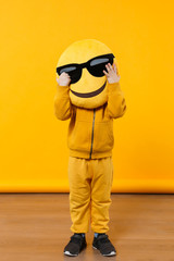 Wall Mural - Little cute kid boy 3-4 years old wearing yellow clothes isolated on bright orange wall background, children studio portrait. People sincere emotions, childhood lifestyle concept. Mock up copy space.