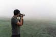 © Danil - A man with a camera in the fog takes pictures