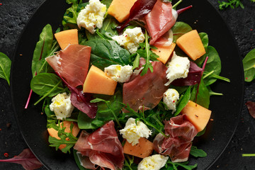 Parma ham and melon salad with mozzarella, green leaves mix