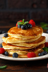 Wall Mural - Homemade american pancakes with fresh blueberry, raspberries and honey. Healthy morning breakfast. rustic style