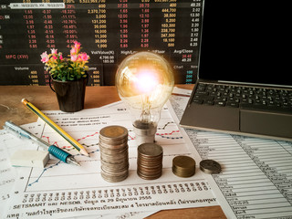 Light bulbs are placed on business accounting documents and the concept of energy saving and financial accounting of the company.