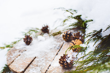 Christmas decor. Fir cones and  juniper branches on a wooden background. Snow still life. Winter.