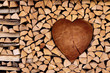 Firewood, nicely assembled in the shape of heart, romantic background, wooden texture, nature background