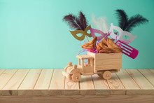 Jewish Holiday Purim Background With Toy Truck, Carnival Mask, Noisemaker And Hamantaschen Cookies