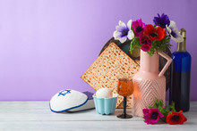 Jewish Holiday Passover Background With Flowers, Wine, Matzo And Seder Plate On Wooden Table
