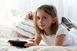 Preteen school girl of 8-9 years old playing on tablet pc at home