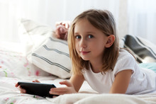 Preteen School Girl Of 8-9 Years Old Playing On Tablet Pc At Home