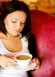 © Raisa Kanareva - young woman sitting in a cafe drinking coffee