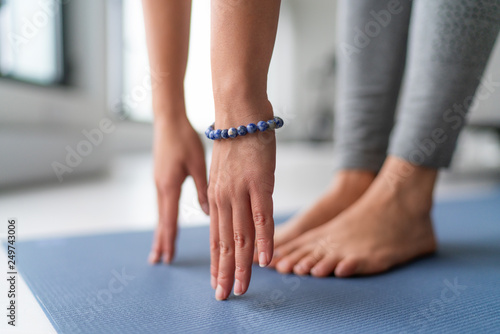 Cuadros en Lienzo Yoga at home exercise in living room house - woman on fitness mat training stretching legs touching toes