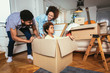 © Mediteraneo - African American family, parents and daughter, unpacking boxes and moving into a new home, having fun.