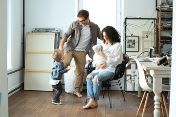 Wall Mural - Happy young family laughing and dancing at homу