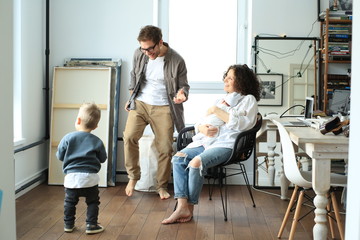 Wall Mural - Happy young family laughing and dancing at homу