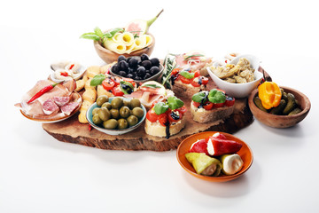 Italian antipasti wine snacks set. Cheese variety, Mediterranean olives, pickles, Prosciutto di Parma, tomatoes, artichokes