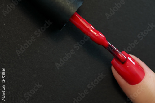 Red Finger nail point isolated black background with nail polish Lerretsbilde