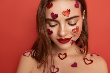 Wall Mural - Shy naked brunette girl is decorated with heart-shaped stickers indoors