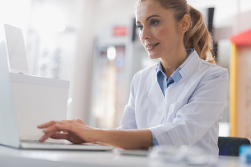 Sticker - Concentrated female optician using her laptop for work