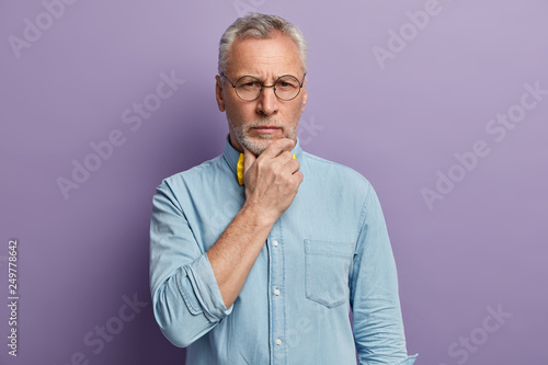 Headshot Of Attractive Wrinkled Man With Grey Hair Holds Chin