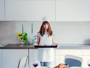 Wall Mural - young girl in chef clothes with baked donuts