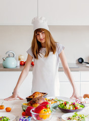 Wall Mural - young girl in chef clothes with Easter eggs and other dishes