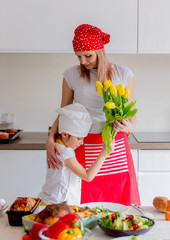 Wall Mural - young mother and daughter in chef clothes cooking