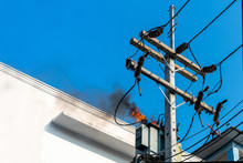 Power Pylon Overload Or Electric Short Circuit At Transformer On Poles And Fire Or Flame With Smoke On Blue Sky