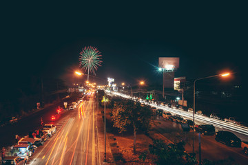 Traffic at night in Sakon Nakhon Thailand with fireworks, year-end celebrations