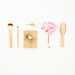 Hairdresser composition of pink peony with hairbrush, tassel and gifts box on white background. Flat lay, top view