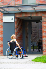 Wall Mural - woman on wheelchair entering the building