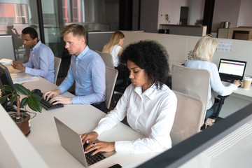 Wall Mural - Diverse millennial employees sitting at desk working in coworking space