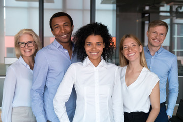 Black team leader photographing with workmates in office