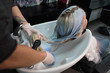 © strigana - Beauty concept - Professional hairdresser applying shampoo, washes color paint off and massaging hair of a customer. Woman having her hair washed in a hairdressing beauty salon