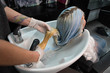 © strigana - Beauty concept - Professional hairdresser applying shampoo, washes color paint off and massaging hair of a customer. Woman having her hair washed in a hairdressing beauty salon