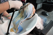 © strigana - Beauty concept - Professional hairdresser applying shampoo, washes color paint off and massaging hair of a customer. Woman having her hair washed in a hairdressing beauty salon