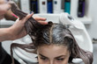© strigana - Beauty concept - Professional hairdresser applying shampoo, washes color paint off and massaging hair of a customer. Woman having her hair washed in a hairdressing beauty salon