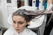 © strigana - Beauty concept - Professional hairdresser applying shampoo, washes color paint off and massaging hair of a customer. Woman having her hair washed in a hairdressing beauty salon