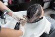 © strigana - Beauty concept - Professional hairdresser applying shampoo, washes color paint off and massaging hair of a customer. Woman having her hair washed in a hairdressing beauty salon