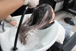 © strigana - Beauty concept - Professional hairdresser applying shampoo, washes color paint off and massaging hair of a customer. Woman having her hair washed in a hairdressing beauty salon