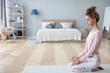 © BestForYou - Attractive young woman working out at home, doing yoga exercise on white mat.