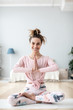 © BestForYou - Positive female in lotus pose on yoga mat on home interior.