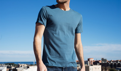 Photo of a man wearing blue t-shirt. Blue sky on background