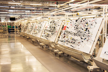 production room with stands for manufacturing electric wiring for cars at a modern plant