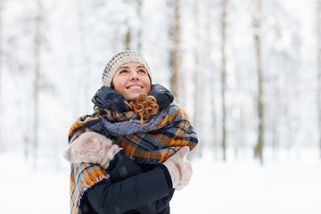 Wall Mural - Waist up portrait of happy young woman in winter forest having fun and enjoying snow, copy space